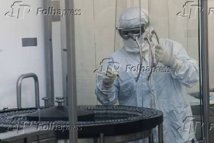 Funcionário da Fiocruz trabalha na etapa de envase da vacina contra a Covid-19
